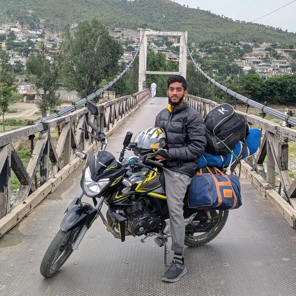 Muhammad Haris on a motorbike tour across a suspension bridge in northern Pakistan